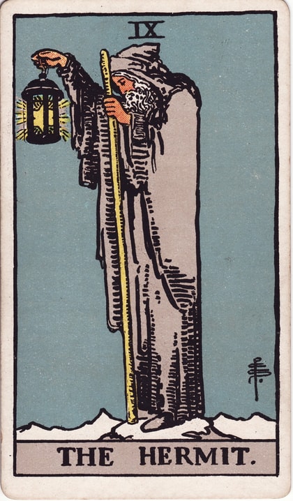 The Hermit, card IX, holding a star-lit lantern and yellow staff on snowy ground in a gray robe.